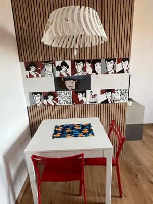 a white table with a red chair and a lamp at Duck House Gemelli in Rome