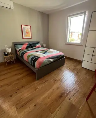 a bedroom with a bed and a wooden floor at Duck House Gemelli in Rome