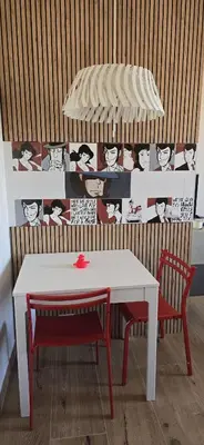 a table and two chairs and a white table and a table and a wall at Duck House Gemelli in Rome