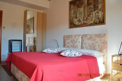 a bedroom with a red bed with two pillows on it at kis inn affitacamere guesthouse in Rome