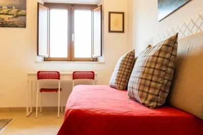 a bedroom with a red bed with two pillows at kis inn affitacamere guesthouse in Rome