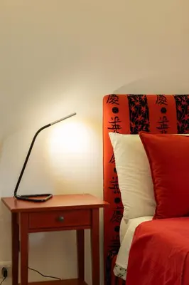 a lamp sitting on a table next to a bed at kis inn affitacamere guesthouse in Rome
