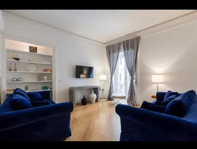 a living room with two blue couches and a television at Rome Luxury House 5stars in Rome