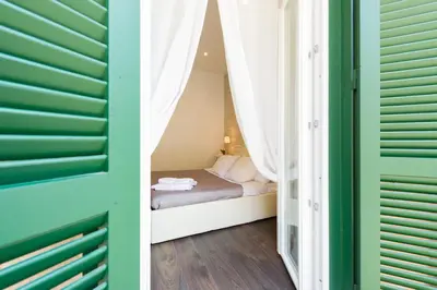 a bedroom with a bed in a room with green shutters at Nido all'Aventino in Rome
