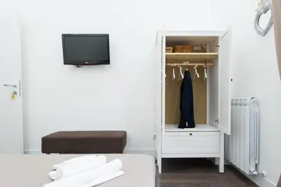 a bedroom with a closet with a tv and a bed at Nido all'Aventino in Rome