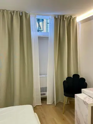 a bedroom with curtains and a chair next to a window at Vivi Roma in Rome