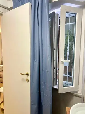 a door with a blue curtain next to a window at Vivi Roma in Rome