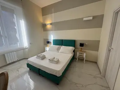 a bedroom with a bed with a green headboard at Roma Palace Suite in Rome