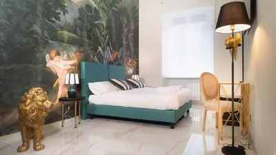 a bedroom with a blue bed and a large painting at Roma Palace Suite in Rome