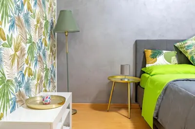 a bedroom with a green bed and a table at Renè home - Ponte Milvio in Rome
