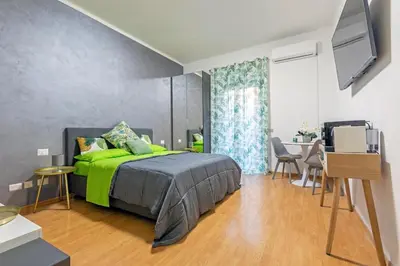 a bedroom with a green bed and a table at Renè home - Ponte Milvio in Rome