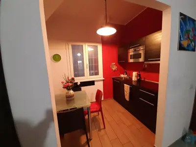 a kitchen with red walls and a small table and a tableablish at Lovely flat next to vatican - private entrance in Rome