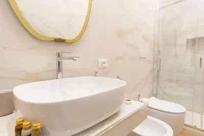 a white bathroom with a sink and a toilet at Elegantis La ParioLina Apartment in Rome