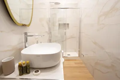 a white bathroom with a sink and a shower at Elegantis La ParioLina Apartment in Rome