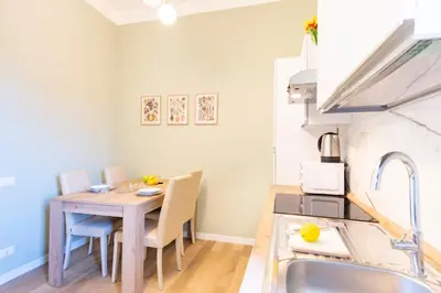 a kitchen and dining room with a wooden table and chairs at Elegantis La ParioLina Apartment in Rome