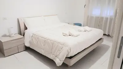 a white bed with two stuffed animals on it at BIBI San Giovanni Roma in Rome