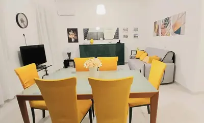 a dining room with a table and yellow chairs at BIBI San Giovanni Roma in Rome