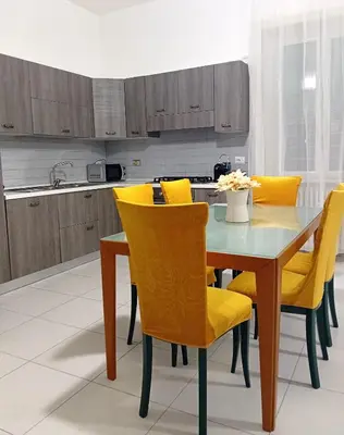 a kitchen with a dining table and yellow chairs at BIBI San Giovanni Roma in Rome