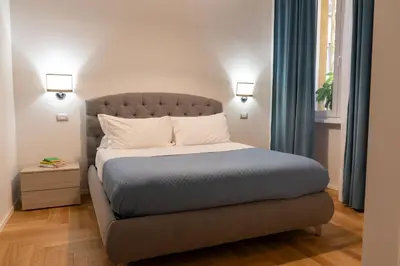 a bedroom with a bed and a window with blue curtains at MADI Collection Colosseum in Rome