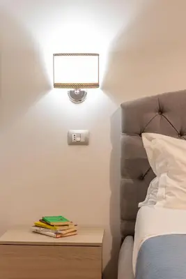 a bedroom with a bed and a nightstand with a lamp at MADI Collection Colosseum in Rome