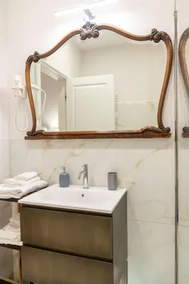 a bathroom with a sink and a mirror at MADI Collection Colosseum in Rome