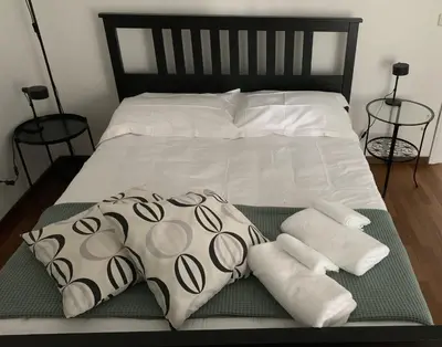 a bed with two pillows and towels on it at Casa verde di Mia in Rome