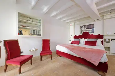 a bedroom with a bed and two red chairs at Colosseo nei Fori Imperiali by Luxury Getaways in Rome