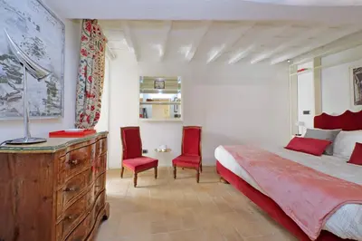 a bedroom with a bed and two red chairs at Colosseo nei Fori Imperiali by Luxury Getaways in Rome