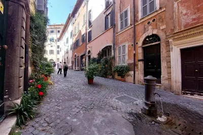 an alley with buildings and people walking down a street at Colosseo nei Fori Imperiali by Luxury Getaways in Rome