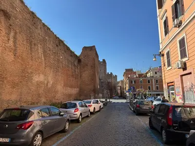 a city street with cars parked next to a wall at Nuovo monolocale a 15 minuti dalla Stazione Termini in Rome