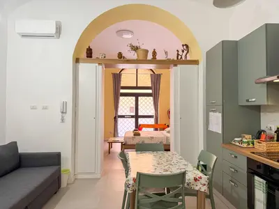 a kitchen and dining room with a table and a couch at Nuovo monolocale a 15 minuti dalla Stazione Termini in Rome