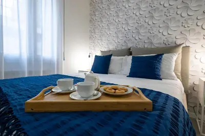a tray with two cups and cookies on a bed at Roma 2 minuti a piedi dal Vaticano in Rome