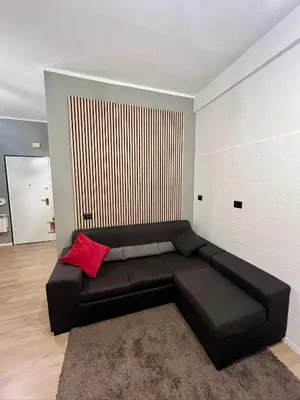 a black couch in a living room with a red pillow at Roiti House Holiday - Roma da Vivere in Rome