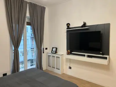 a bedroom with a flat screen tv on a wall at Roiti House Holiday - Roma da Vivere in Rome