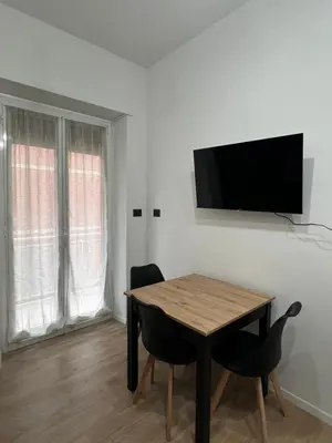 a dining room with a table and a television on a wall at Roiti House Holiday - Roma da Vivere in Rome