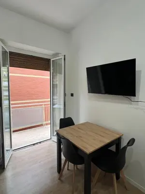 a dining room with a table and a television on a wall at Roiti House Holiday - Roma da Vivere in Rome