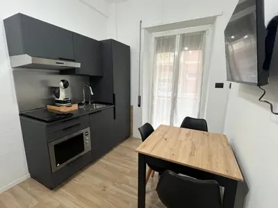 a small kitchen with a wooden table and a table and chairs at Roiti House Holiday - Roma da Vivere in Rome