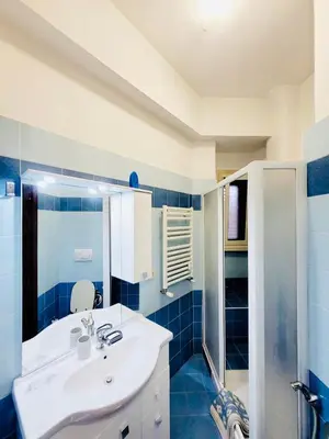 a blue and white bathroom with a sink and a shower at House 5 minutes walk from Vatican Museums in Rome