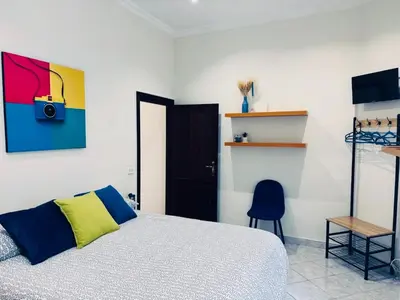 a bedroom with a bed and a blue chair at House 5 minutes walk from Vatican Museums in Rome