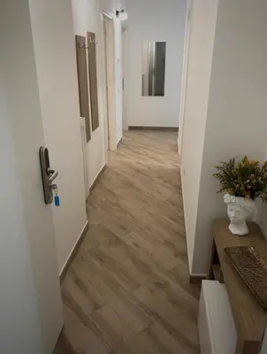 a hallway with white walls and wooden floors at La casa di Tilde Roma POLDO in Rome