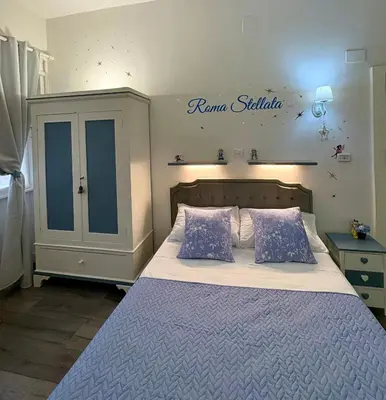 a bedroom with a large bed with blue pillows at Roma Stellata in Rome