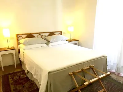 a bedroom with a large bed with white sheets and pillows at Vicolo del Lupo Guesthouse in Rome