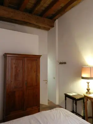 a bedroom with a wooden cabinet and a bed at Vicolo del Lupo Guesthouse in Rome