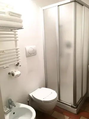 a bathroom with a shower and a toilet and a sink at Vicolo del Lupo Guesthouse in Rome