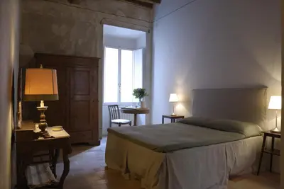 a bedroom with a bed and a table and a chair at Vicolo del Lupo Guesthouse in Rome