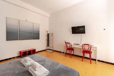 a bedroom with a bed and a desk and two red chairs at Roma San Pietro - L'Angolo di Marley apt in Rome