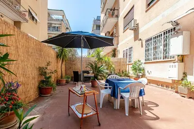 a patio with a blue table and chairs and an umbrella at Roma San Pietro - L'Angolo di Marley apt in Rome