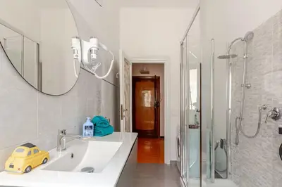 a bathroom with a sink and a mirror and a shower at Roma San Pietro - L'Angolo di Marley apt in Rome