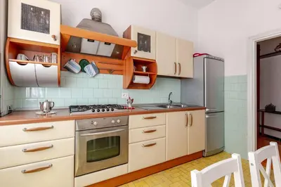 a kitchen with white cabinets and a stainless steel refrigerator at Roma San Pietro - L'Angolo di Marley apt in Rome