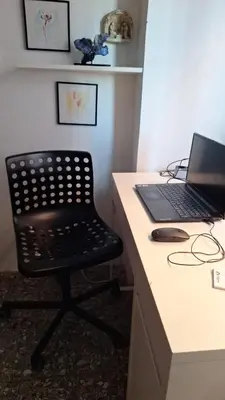 a black chair sitting next to a desk with a laptop at Il Pineto in Rome